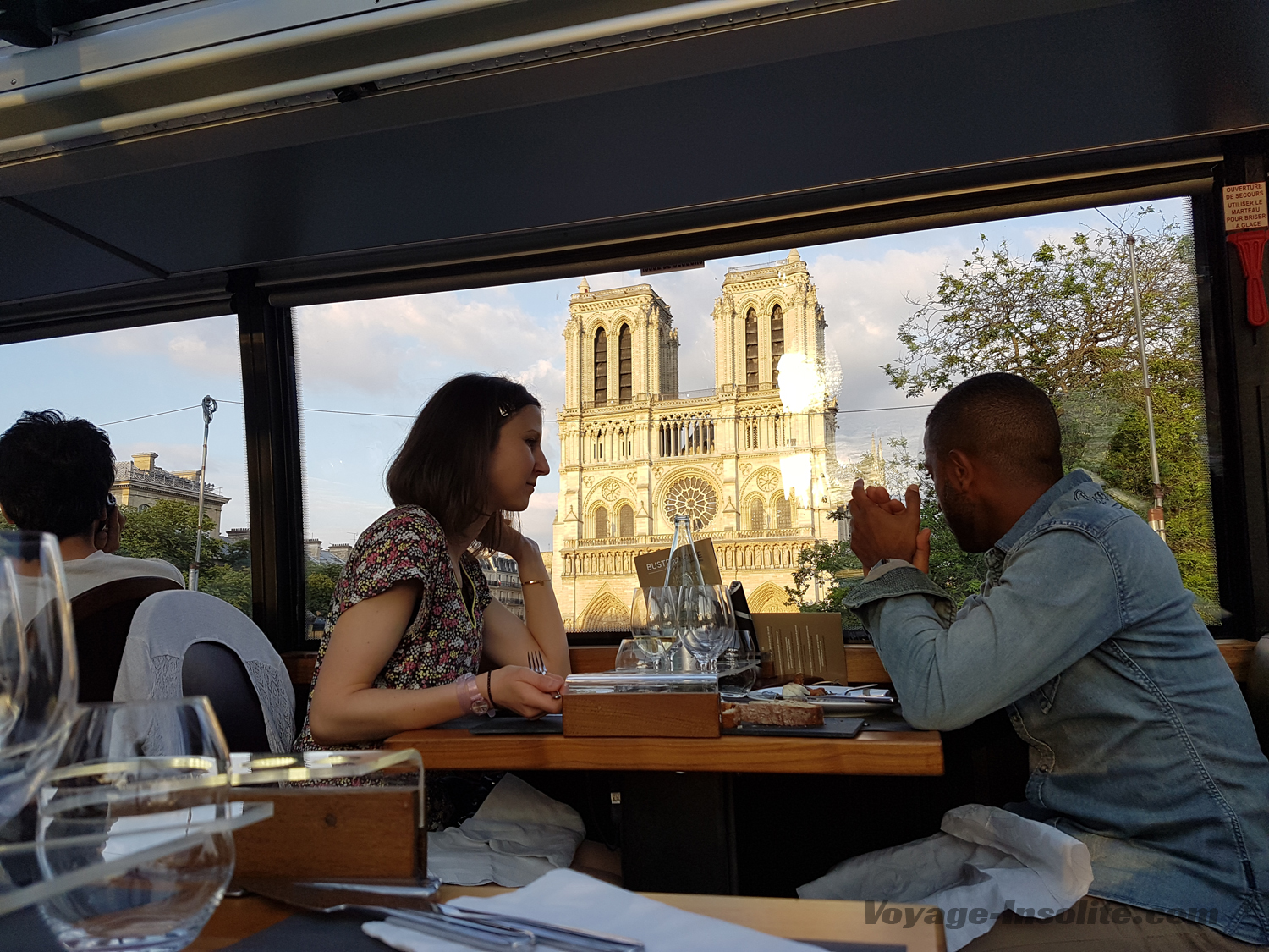 Couple profitant de la vue sur Notre Dame de Paris à bord du bus restaurant, le Bustronome