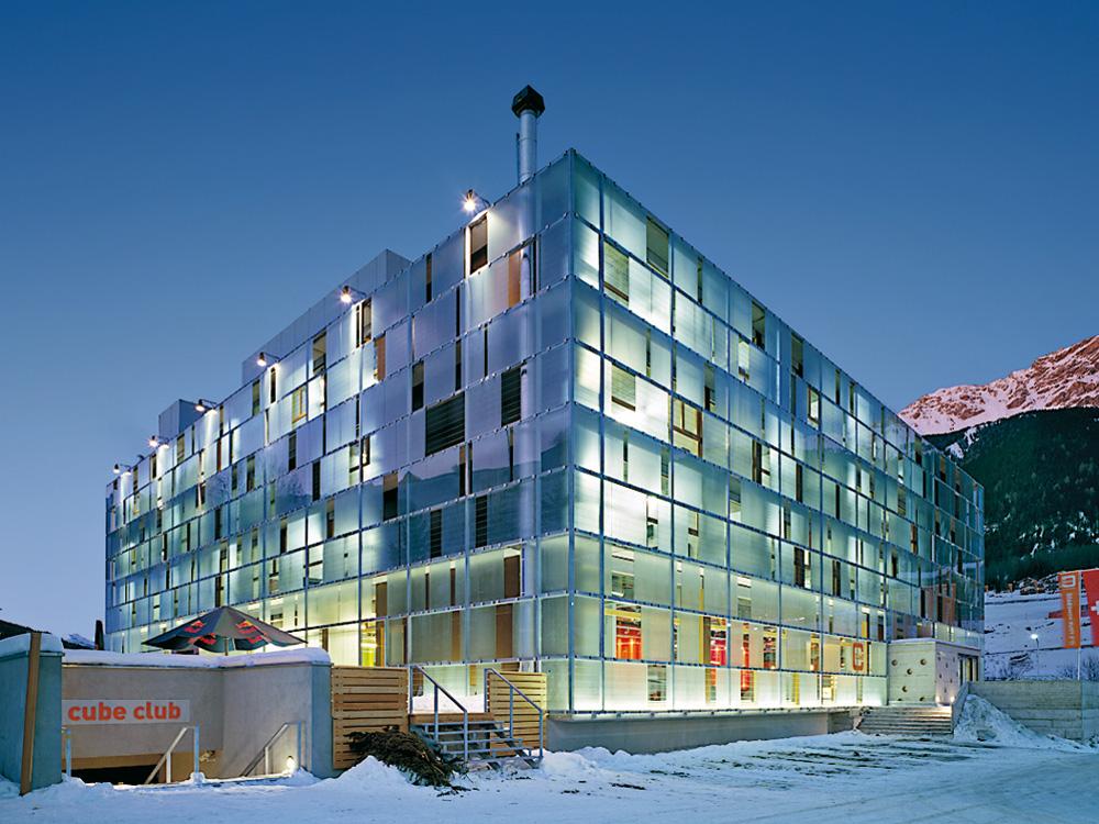 Voici le Cube hôtel Savognin sous la neige en Suisse